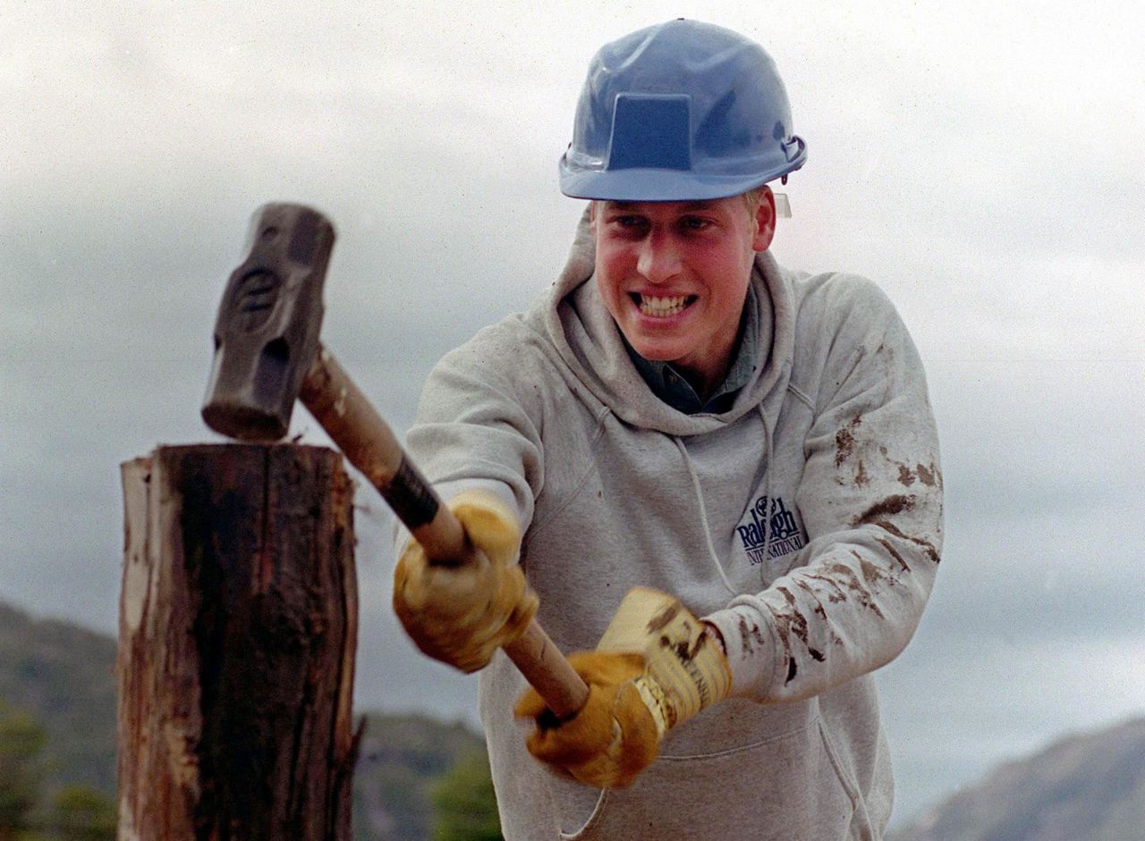 Prince William hammers a log while helping construct walkways in a remote village in Chile in 2000.