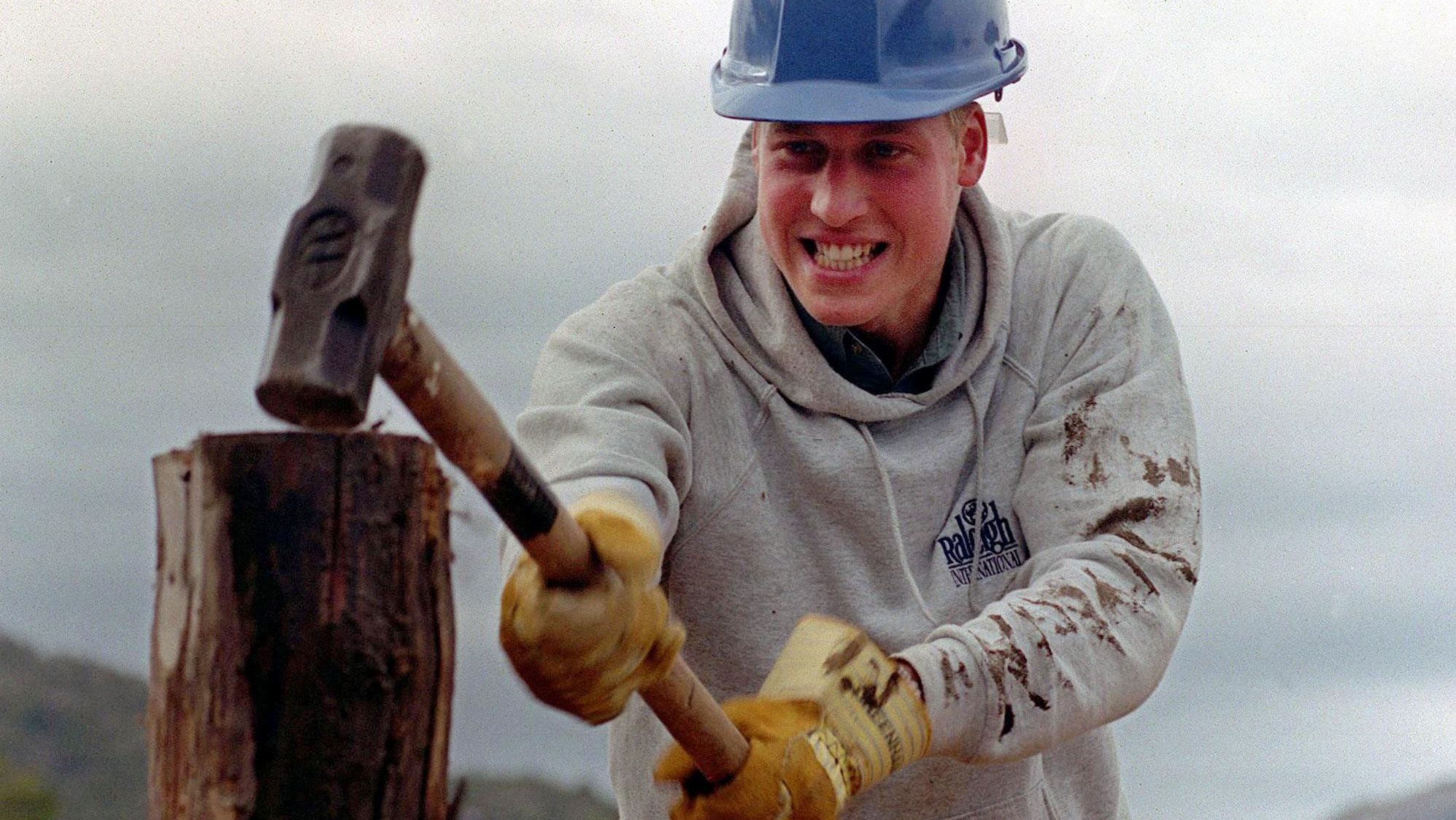Prince William hammers a log while helping construct walkways in a remote village in Chile in 2000.