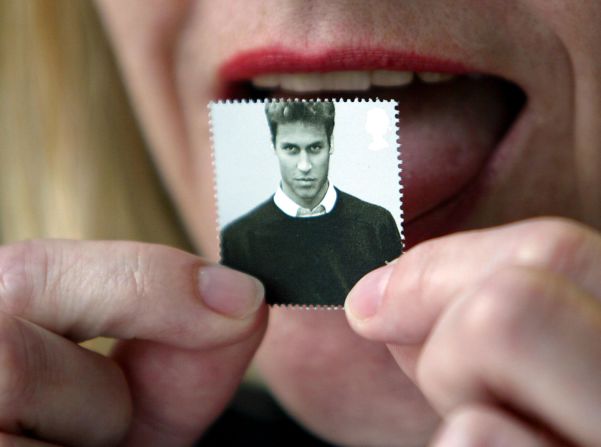 A London office worker licks a first-class stamp that was issued to mark Prince William's 21st birthday in 2003. Commemorative coins were also minted for the occasion.