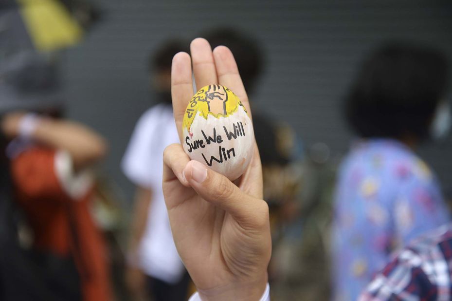 An anti-coup protester raises a decorated Easter egg along with the three-fingered salute of resistance during a demonstration in Yangon on April 4.