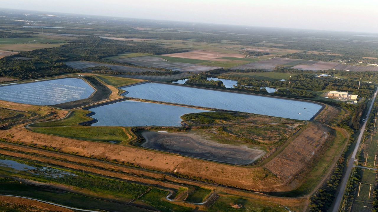 This aerial photo taken from an airplane shows a reservoir near the old Piney Point phosphate mine, Saturday, April 3, 2021 in Bradenton, Fla. Florida Gov. Ron DeSantis declared a state of emergency Saturday after a significant leak at a large pond of wastewater threatened to flood roads and burst a system that stores polluted waters. The pond where the leak was discovered is at the old Piney Point phosphate mine, sitting in a stack of phosphogypsum, a waste product from manufacturing fertilizer that is radioactive. (Tiffany Tompkins/The Bradenton Herald via AP)