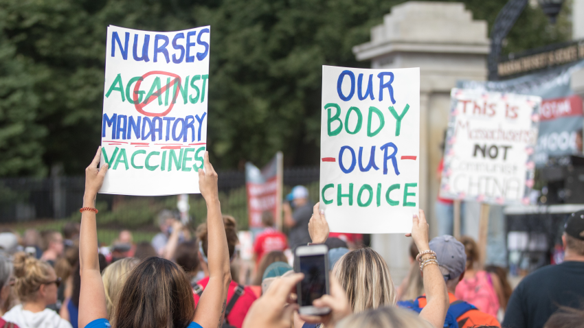 BOSTON, MA - AUGUST 30:  Anti-vaccine activists hold up signs during a protest in front of the Massachusetts State House against Governor Charlie Baker's mandate that all Massachusetts school students enrolled in child care, pre-school, K-12, and post-secondary institutions must receive the flu vaccine this year on August 30, 2020 in Boston, Massachusetts.  (Photo by Scott Eisen/Getty Images)