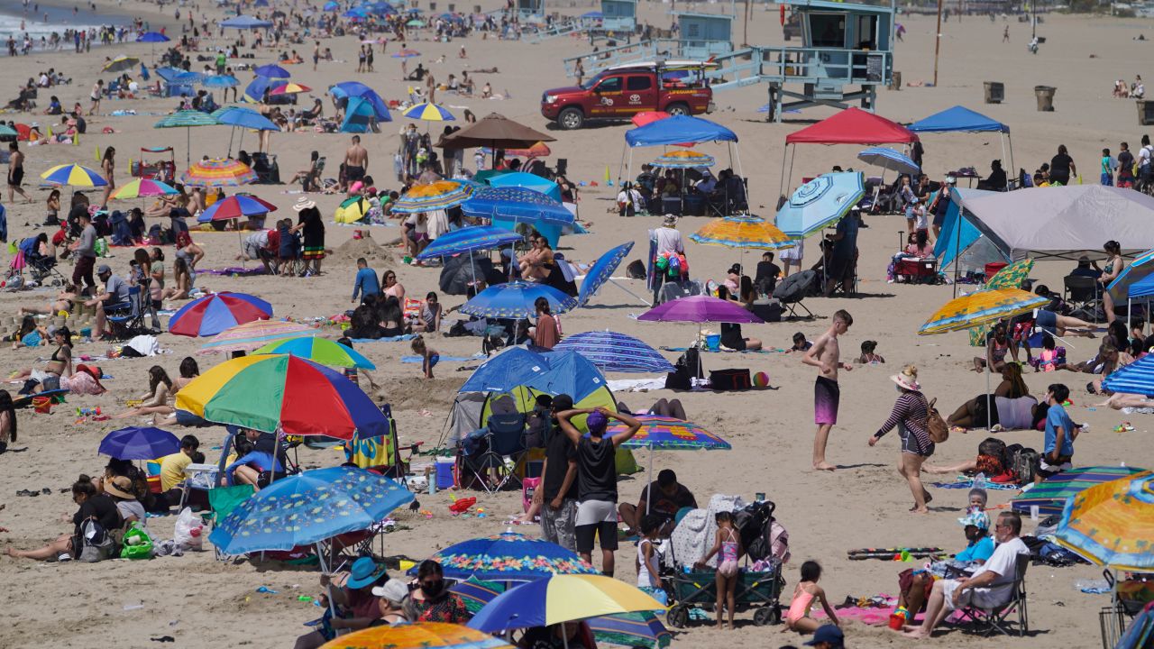 People enjoy the hot weather on Santa Monica Beach in Santa Monica, Calif., Wednesday, March 31, 2021. Half of the state's nearly 40 million people are now in the state's second-least restrictive orange tier amid low coronavirus case rates and increased vaccinations. Health officials in California and across the country are urging caution because of a troubling rise in new cases of COVID-19.  (AP Photo/Damian Dovarganes)