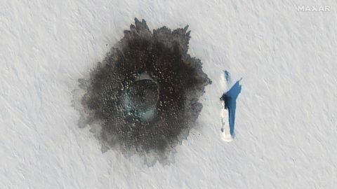 A Russian Delta IV submarine photographed on top of ice near Alexandra Island on March 27, during an exercise, with a likely hole blown in the ice to its left from underwater demolition.