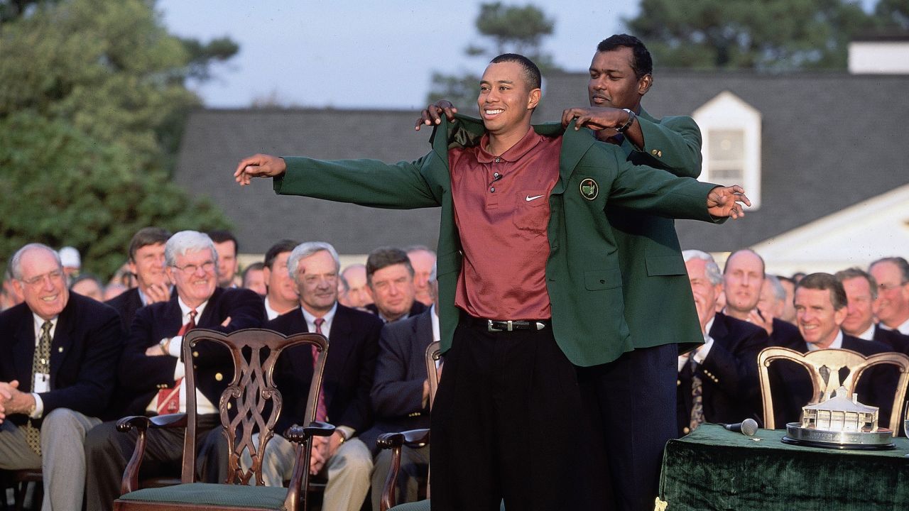 Woods puts on the Green Jacket in 2001 with the help of the previous year's champion Vijay Singh. 