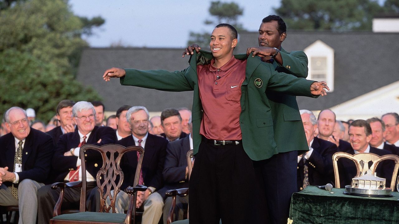 Woods puts on the Green Jacket in 2001 with the help of the previous year's champion Vijay Singh.