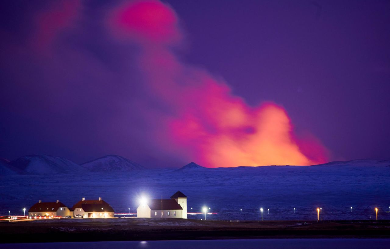 A red shimmer from the volcano is seen behind the Bessastadir, the official residence of the President of Iceland, on March 23.