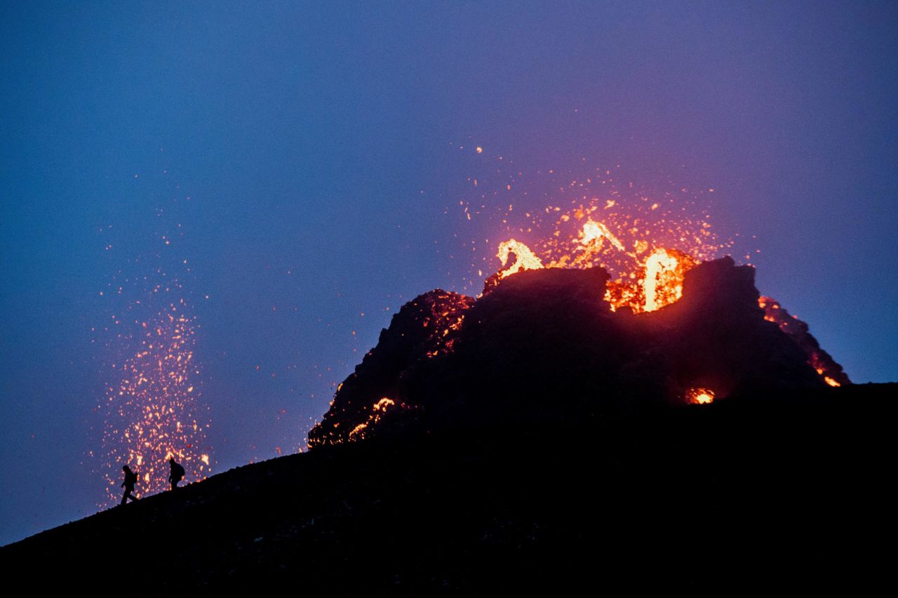 People walk near the volcano on March 21.