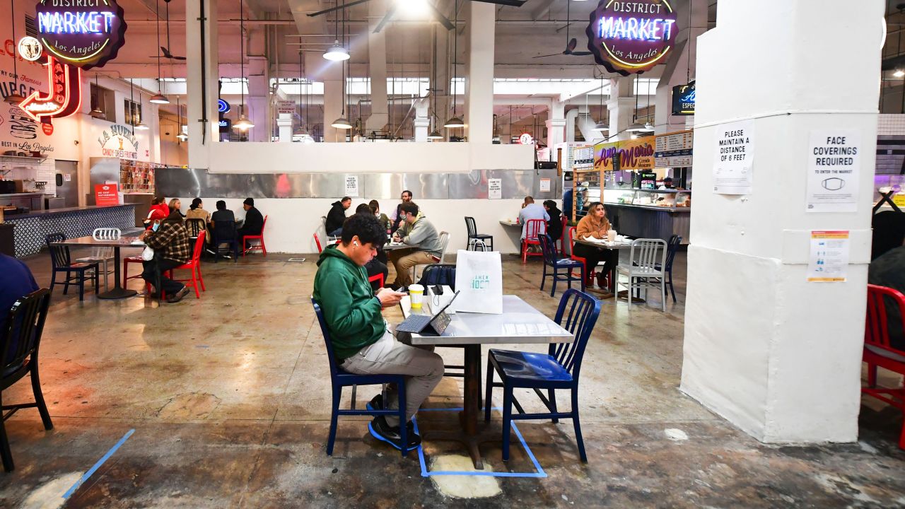 Above, people enjoy lunch at Grand Central Market as indoor dining reopens in Los Angeles on March 15. Here's what experts have said about the safety of dining out -- depending on your vaccination status. 