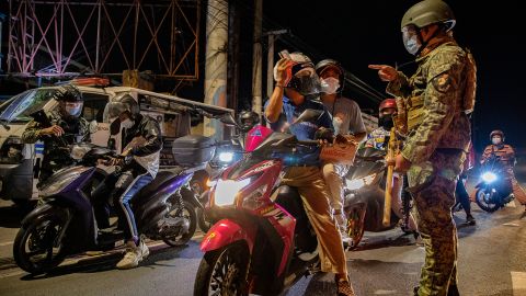 Police officers inspect motorists at a quarantine checkpoint, on March 29, 2021 in Marikina, Metro Manila, Philippines.