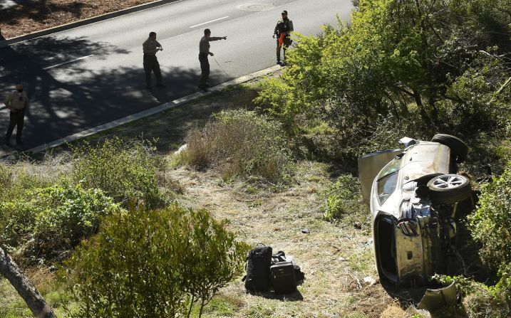 Law enforcement officers investigate the scene of Woods' rollover crash in Rancho Palos Verdes, California, in February 2021. Woods <a href="index.php?page=&url=https%3A%2F%2Fwww.cnn.com%2F2021%2F04%2F07%2Fus%2Ftiger-woods-update-crash-cause%2Findex.html" target="_blank">suffered serious leg injuries</a> in the one-car accident and had to be pulled from his vehicle by emergency responders. 