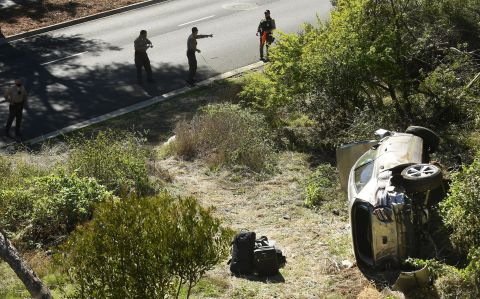 Law enforcement officers investigate the scene of Woods' rollover crash in Rancho Palos Verdes, California, in February 2021. Woods <a href="https://www.cnn.com/2021/04/07/us/tiger-woods-update-crash-cause/index.html" target="_blank">suffered serious leg injuries</a> in the one-car accident and had to be pulled from his vehicle by emergency responders. 