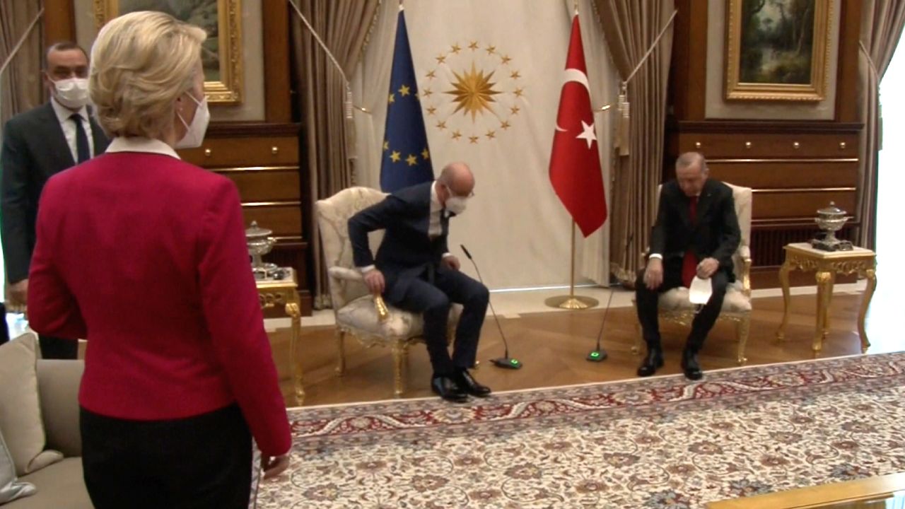 European Commission President Ursula von der Leyen (left) is seen standing as European Council President Charles Michel (center) and Turkish President Recep Tayyip Erdogan (right) take their seats.
