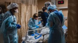 Healthcare workers tend to a patient with Covid-19 who is having difficulty breathing in a Covid holding pod at Providence St. Mary Medical Center in Apple Valley, California.