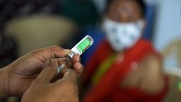 A medical worker prepares to inoculate a woman with the dose of Covishield vaccine against the Covid-19 coronavirus at a government high school in Hyderabad on April 5, 2021. (Photo by Noah Seelam/AFP/Getty Images)