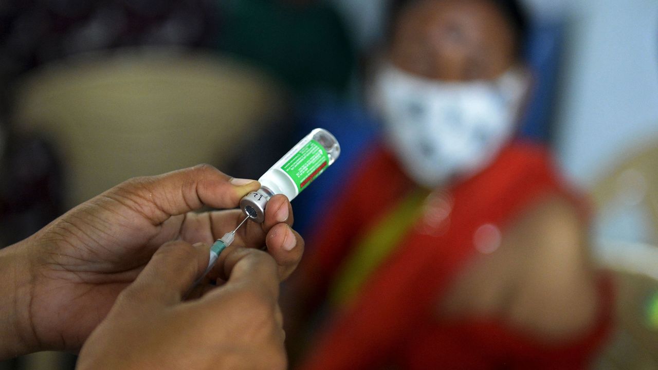 A medical worker prepares to innoculate a woman with a dose of AstraZeneca's vaccine in Hyderabad on Apr. 5.