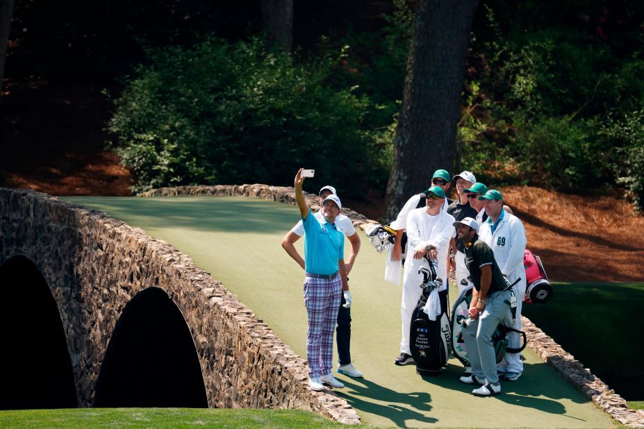 During a practice round on Wednesday, Ian Poulter takes a Hogan Bridge selfie with his playing partners and their caddies.