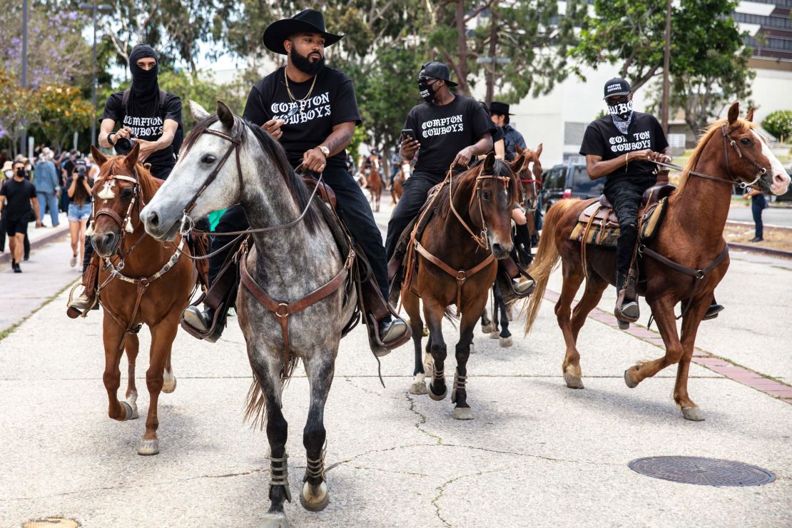 The Compton Cowboys, with Randy Hook at the front, riding in their city near Los Angeles. 