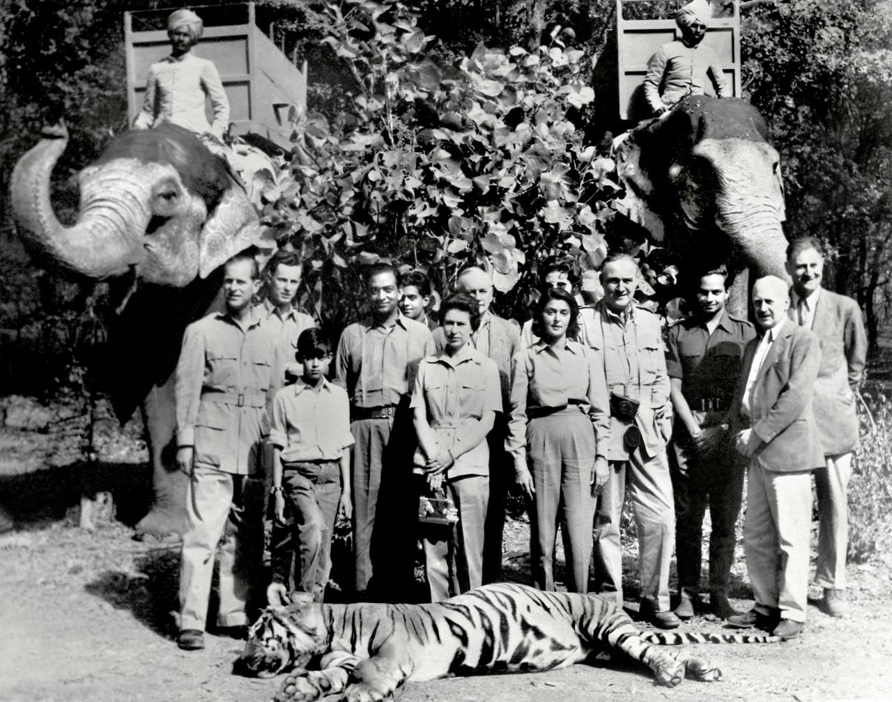 The Queen, center, and Prince Philip, left, pose with a tiger Philip killed on a hunting trip during an official visit to India in 1961. They are seen with the Maharaja and the Maharani of Jaipur.