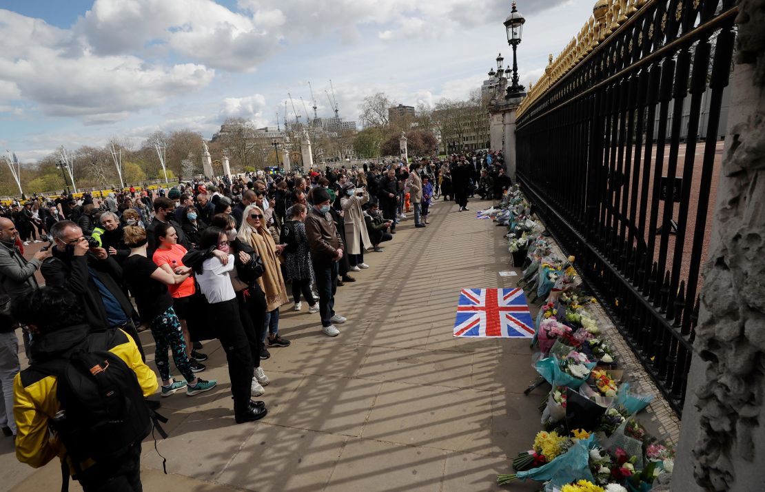 Mourners lay flowers and gather in front of Buckingham Palace. 