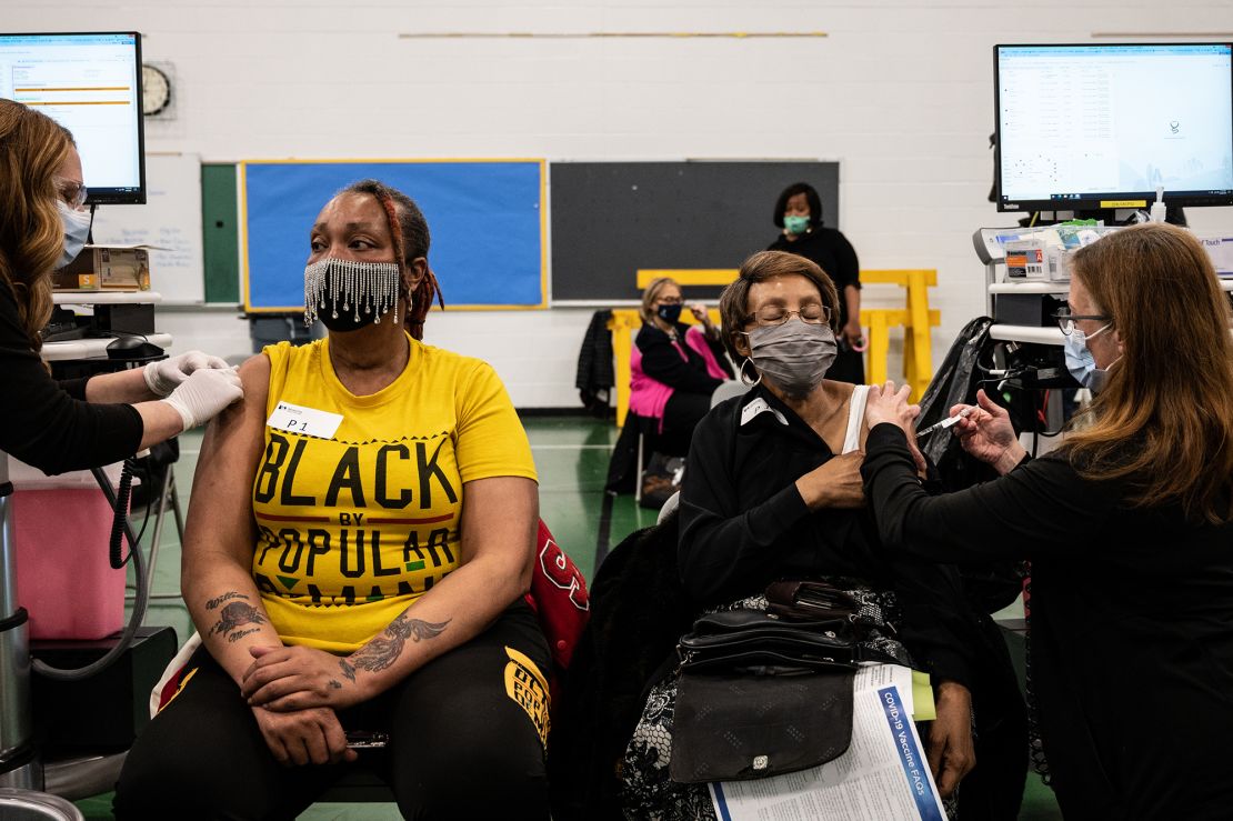 Severe reactions to the vaccine, seen here being administered to two women in Louisville, Kentucky, remain very rare. Side effects like arm soreness, fatigue and nausea are more common.