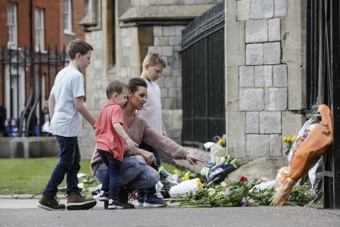 A family looks at flowers outside Windsor Castle on Friday.
