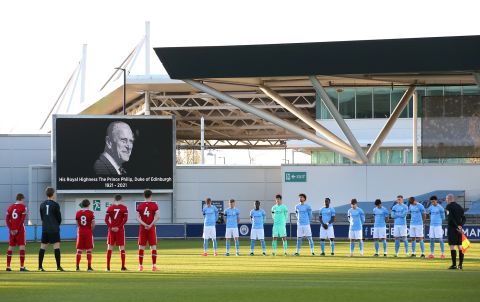 Soccer players stand for two minutes of silence before an under-23 match in Manchester, England.
