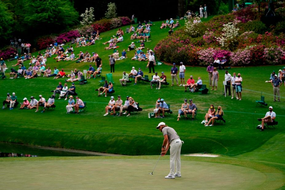 People spread out from one another as they watch Tommy Fleetwood putt on the 16th green on Friday.