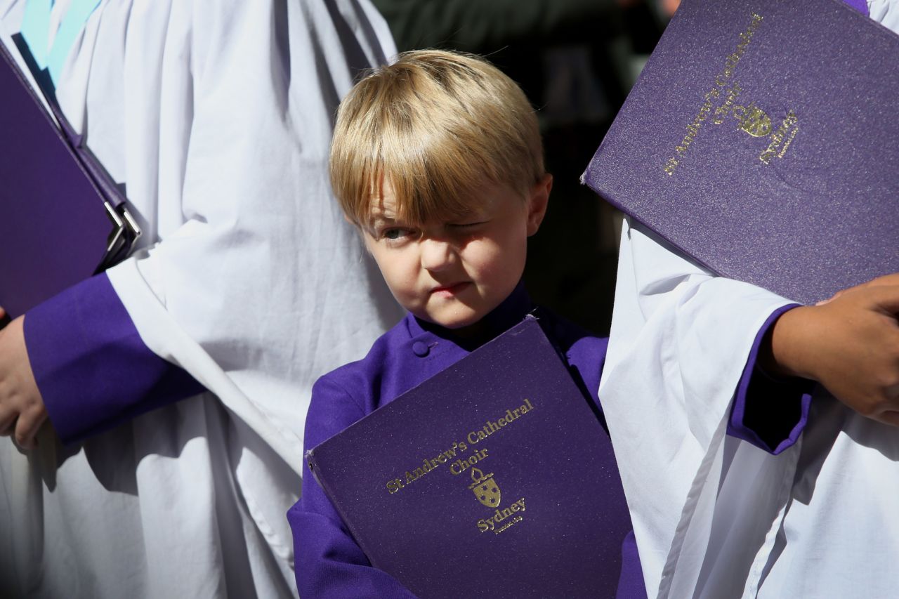 A young member of the St. Andrew's Cathedral choir squints in the sunlight following the commemorative service in Sydney.