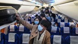 Passengers wearing protective facemasks as a preventive measure against the Covid-19 (the novel coronavirus) leave the plane upon their arrival at the Tianhe International Airport in Wuhan, in Chinas central Hubei province, on January 27, 2021. (Photo by Hector RETAMAL / AFP) (Photo by HECTOR RETAMAL/AFP via Getty Images)