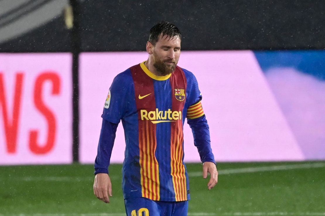 Messi looks on in the pouring rain.
