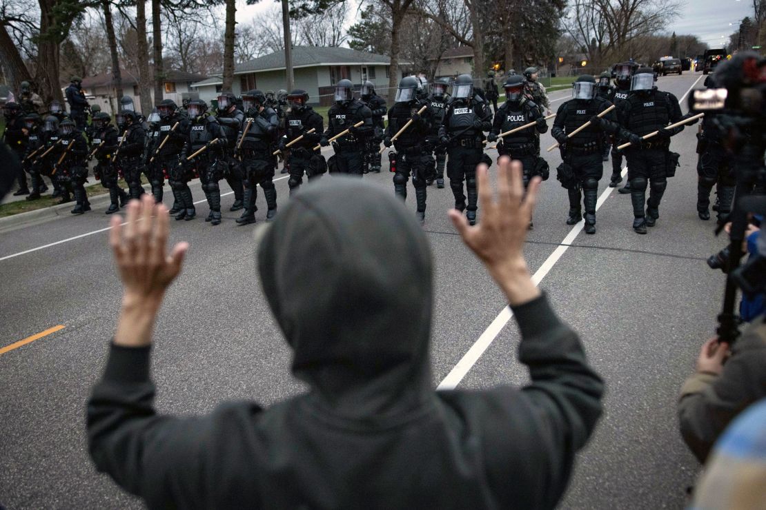 A person raises their hands as police approach near the site where Daunte Wright was shot in Brooklyn Center, Minnesota.