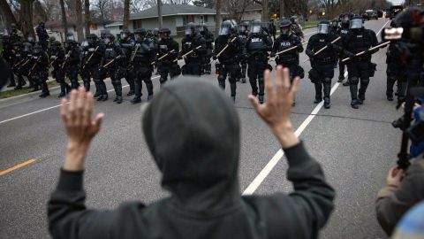 A person raises their hands as police approach near the site where Daunte Wright was shot in Brooklyn Center, Minnesota.