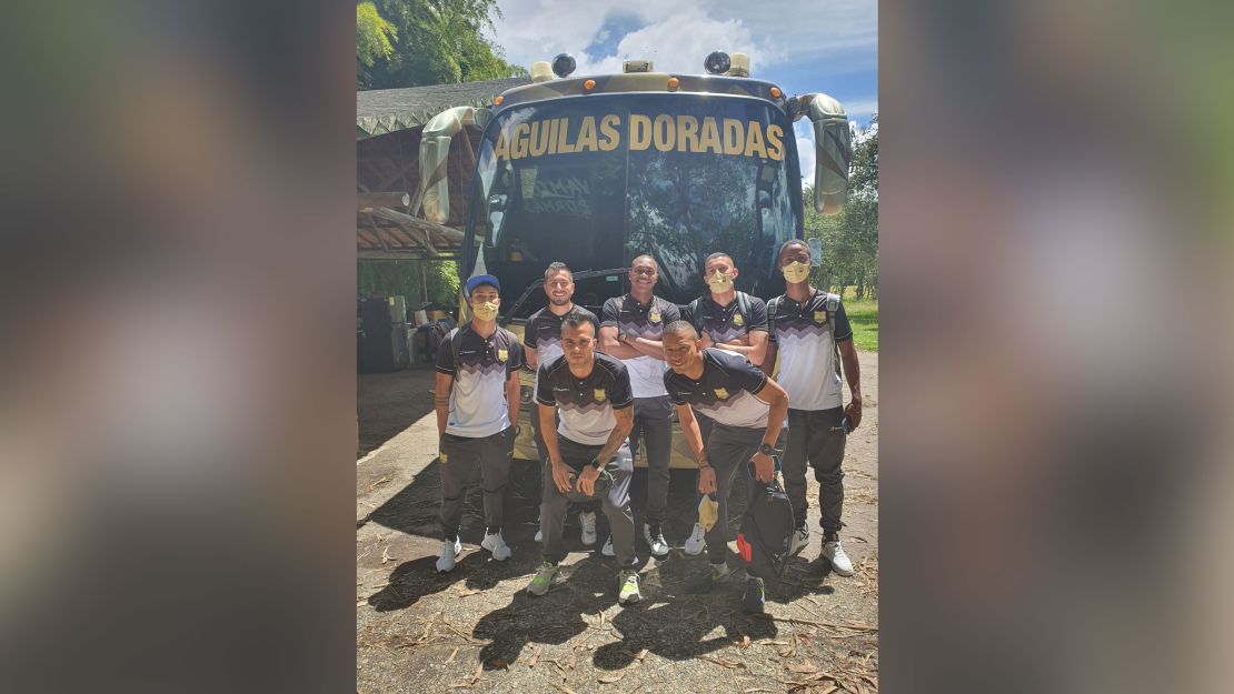 Águilas Doradas' depleted team pose for a photo next to the team bus.