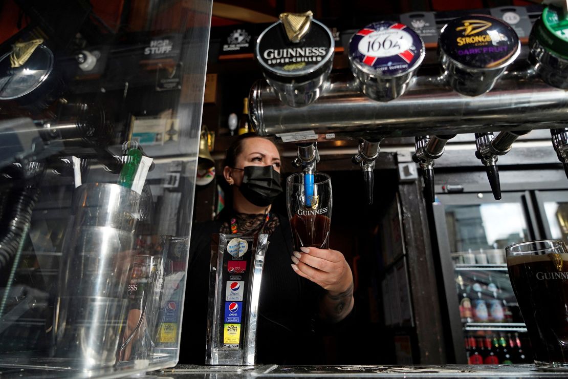 A worker pours a pint at the Half Moon pub in east London as coronavirus restrictions are eased.