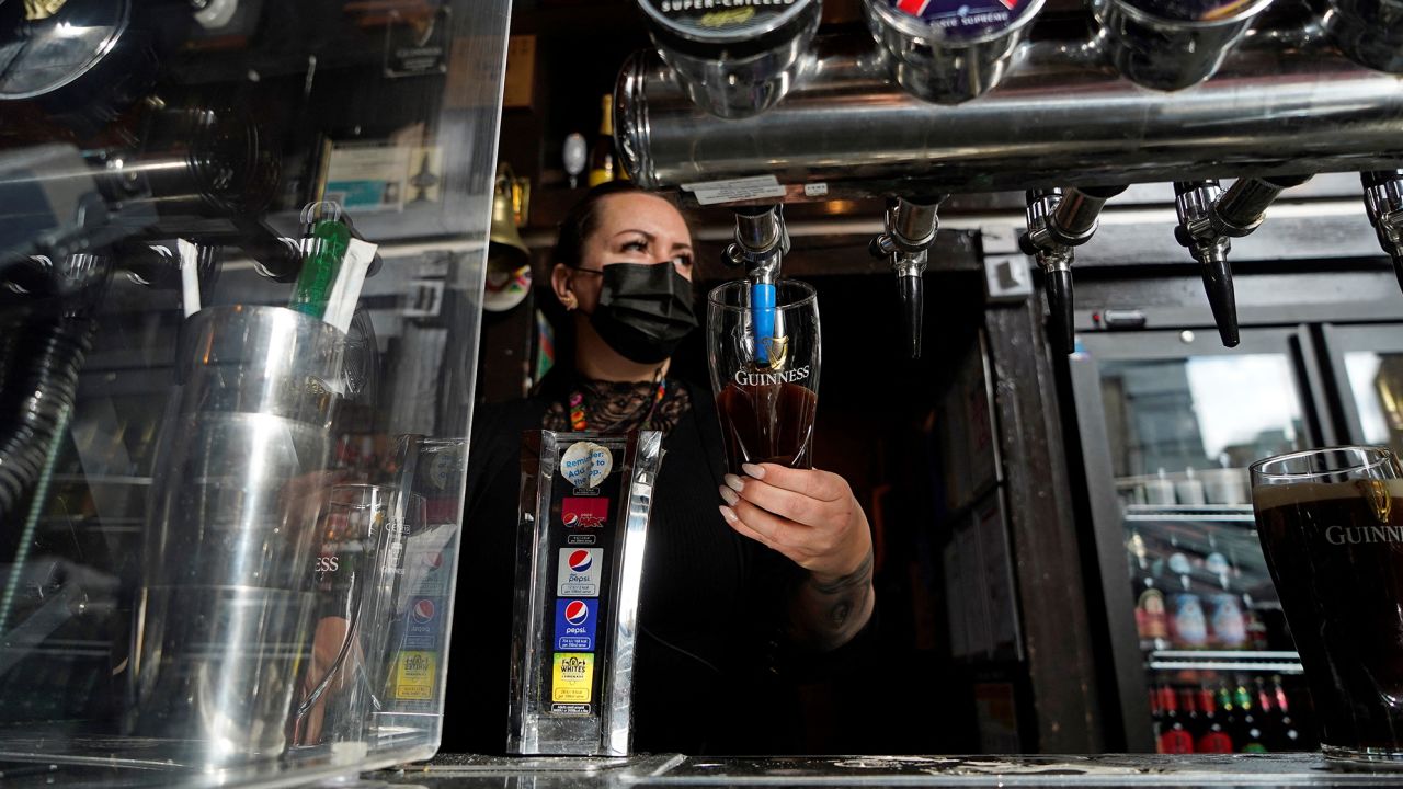 A worker pours a pint at the Half Moon pub in east London as coronavirus restrictions are eased.