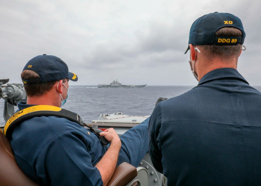 US Navy Cmdr. Robert Briggs and Cmdr. Richard Slye monitor the Chinese aircraft carrier Liaoning from the pilothouse of the guided-missile destroyer USS Mustin on April 4 in the Philippine Sea.