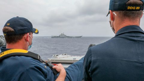US Navy Cmdr. Robert Briggs and Cmdr. Richard Slye monitor the Chinese aircraft carrier Liaoning from the pilothouse of the guided-missile destroyer USS Mustin on April 4.