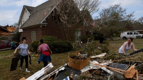 Volunteers clean up debris on March 26, following a tornado that hit the Eagle Point community south of Birmingham, Alabama.