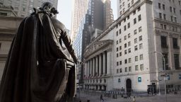 People walk past the New York Stock Exchange (NYSE) and a  statue of George Washington at Wall Street on March 23, 2021 in New York City. - Wall Street stocks were under pressure early ahead of congressional testimony from Federal Reserve Chief Jerome Powell as US Treasury bond yields continued to retreat. (Photo by Angela Weiss/AFP/Getty Images)