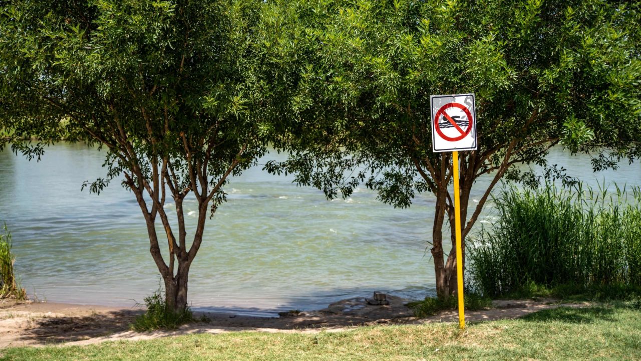 This file photo from 2019 shows a "No Swimming" sign near the Rio Grande in Piedras Negras, Mexico. The mother we met told us her family was on the banks of the river in Piedras Negras when they decided to separate.