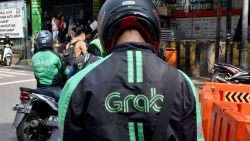 GrabBike riders wait for passengers outside a commuter train station in Jakarta on June 13, 2018. - Toyota said June 13 it was investing 1 billion USD in Asia ride-share company Grab, as the Japanese automaker looks to expand beyond its core business into the "mobility" sector. (Photo by GOH CHAI HIN / AFP)        (Photo credit should read GOH CHAI HIN/AFP via Getty Images)