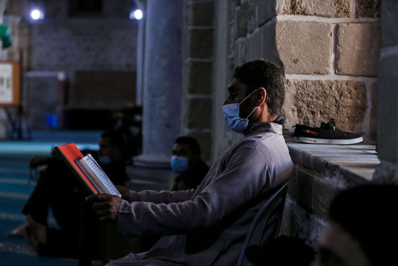 A man reads a copy of the Quran at the Omari Grand Mosque in Gaza City.