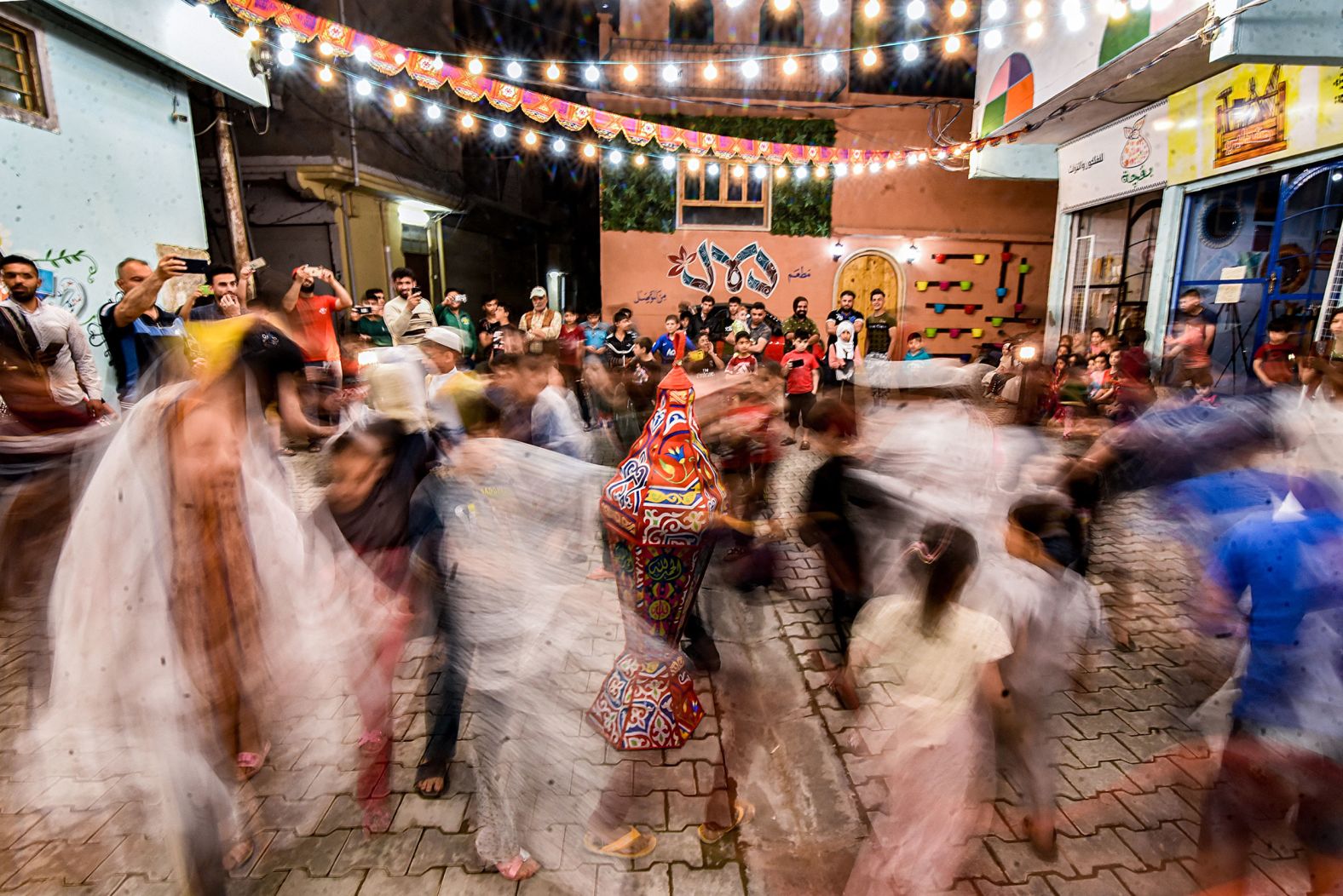 Children dance during a street celebration in Mosul, Iraq. This photo was taken with a long exposure.