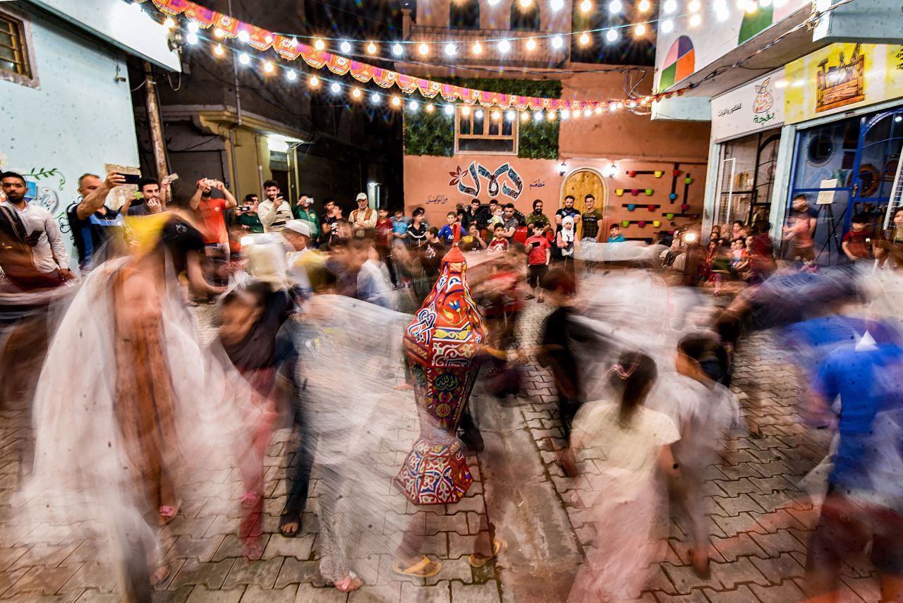 Children dance during a street celebration in Mosul, Iraq. This photo was taken with a long exposure.