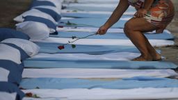 TOPSHOT - A woman lays a rose on top of a mattress symbolizing COVID-19 victims during a protest by the Rio de Paz human rights activist group outside a hospital in Rio de Janeiro, Brazil, on March 24, 2021. - The group were protesting against the rising figures of COVID-19 deaths in the country which saw more than 3000 people die in the last 24 hours. (Photo by CARL DE SOUZA / AFP) (Photo by CARL DE SOUZA/AFP via Getty Images)