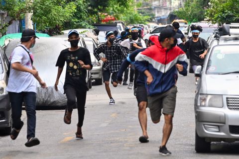Protesters run from security forces during an anti-coup demonstration in Yangon on April 12.