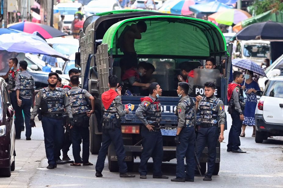 Police talk as they arrive at the site of a demonstration in Yangon on April 12.