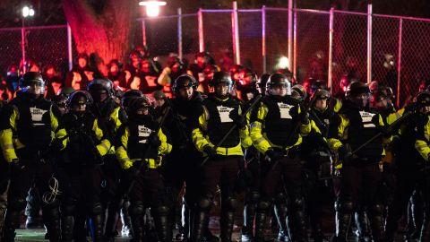 Law enforcement officers advance on demonstrators gathered outside the Brooklyn Center Police Department late Tuesday.