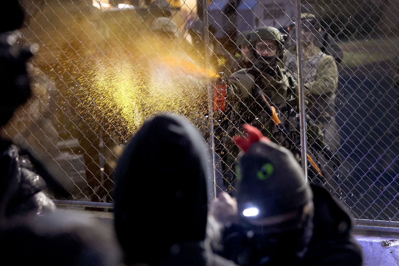 A police officer pepper-sprays demonstrators on Tuesday.